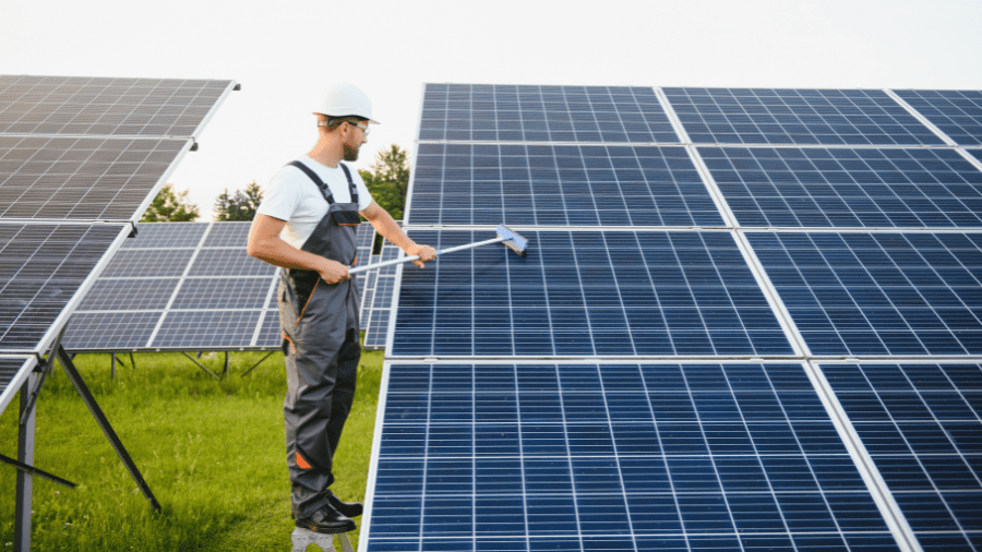 Technician cleaning solar panels on a solar farm