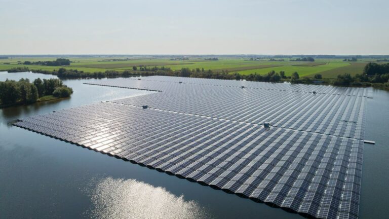 Floating photovoltaic system on a lake with forested slopes.