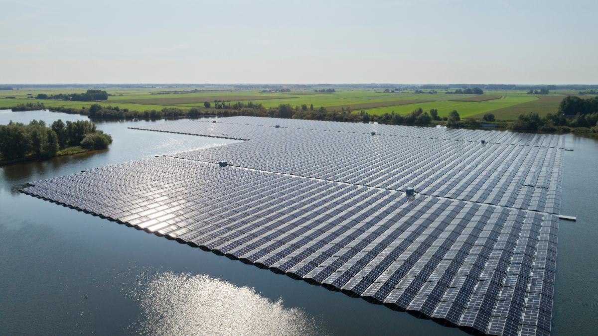 Floating photovoltaic system on a lake with forested slopes.